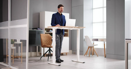 Man using a standing desk to complete his work