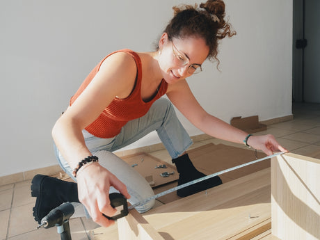 woman measuring desk to go in workspace 