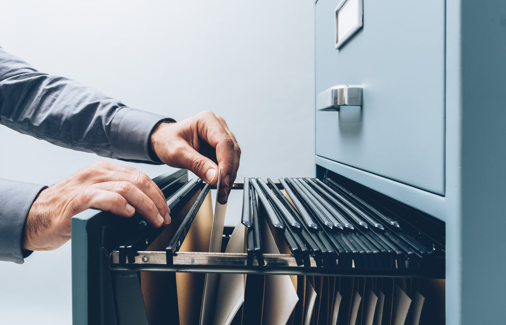 Man searching office storage cabinet 